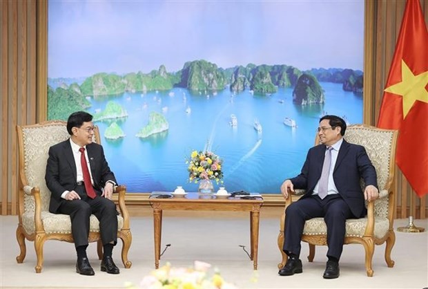 Prime Minister Pham Minh Chinh (R) and Singaporean Deputy Prime Minister and Coordinating Minister for Economic Policies Heng Swee Keat. (Source: VNA)