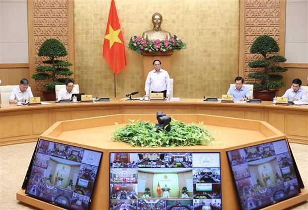 Prime Minister Pham Minh Chinh (standing) speaks at the teleconference on October 1. (Source: VNA)
