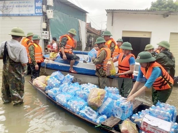 Relief workers offer food and drinking water to flood victims in Nghe An. (Photo: VNA)