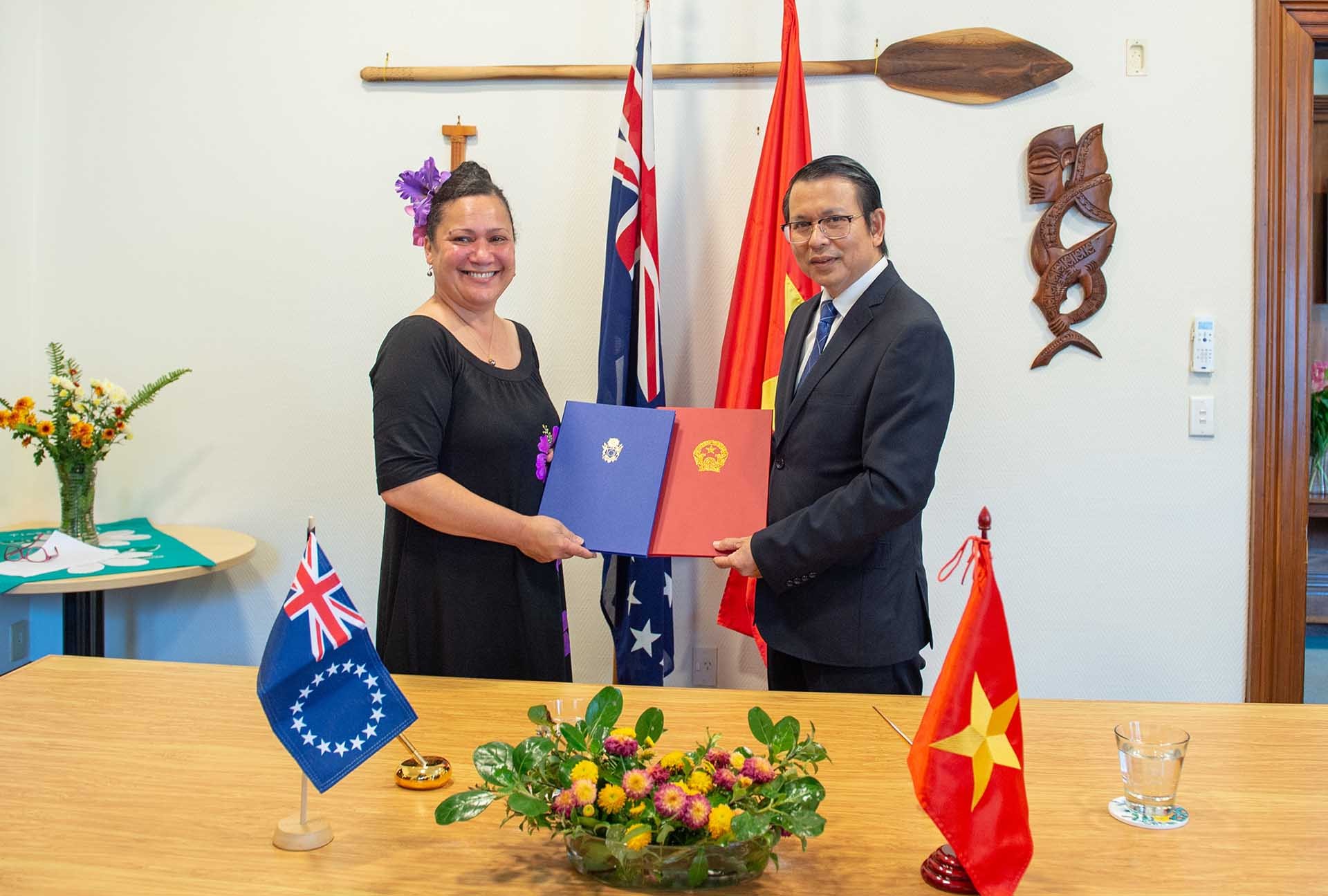 Đại sứ Việt Nam tại New Zealand Nguyễn Văn Trung và Cao ủy Quần đảo Cook tại New Zealand Elizabeth Wright-Koteka ký Thông cáo chung thiết lập quan hệ ngoại giao giữa Việt Nam và Quần đảo Cook.