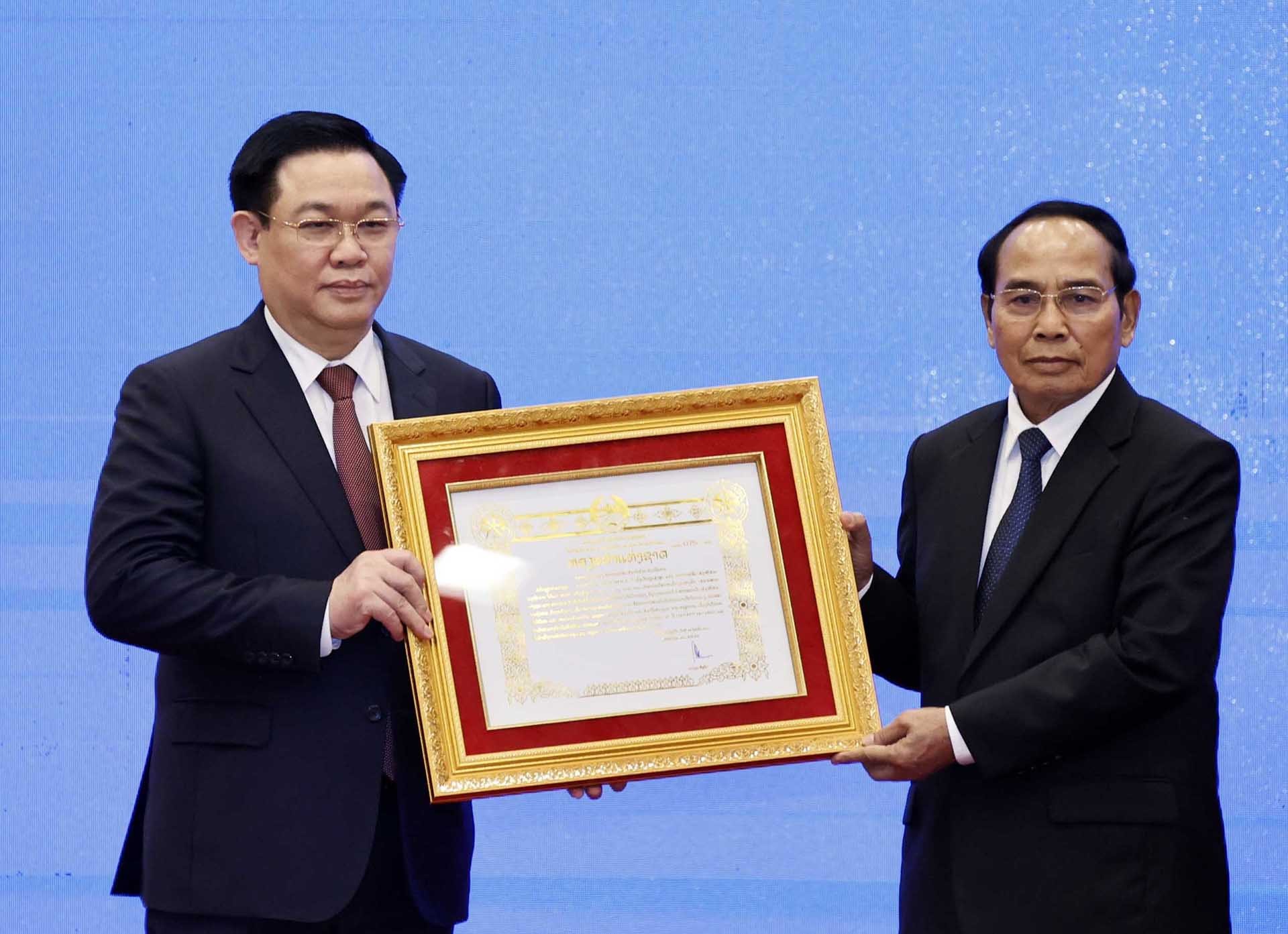Đồng chí Bounthong Chitmany, Ủy viên Bộ Chính trị, Thường trực Ban Bí thư Lào, Phó Chủ tịch nước Lào trao Huân chương Vàng Quốc gia của Lào cho đồng chí Vương Đình Huệ, Uỷ viên Bộ Chính trị, Chủ tịch Quốc hội. (Nguồn: TTXVN) Đồng chí Bounthong Chitmany, Ủy viên Bộ Chính trị, Thường trực Ban Bí thư Lào, Phó Chủ tịch nước Lào trao Huân chương Vàng Quốc gia của Lào cho đồng chí Vương Đình Huệ, Uỷ viên Bộ Chính trị, Chủ tịch Quốc hội. (Nguồn: TTXVN)