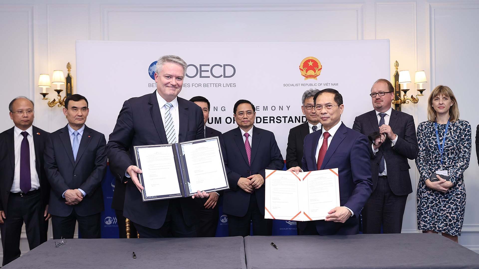 Thủ tướng Phạm Minh Chính chứng kiến Bộ trưởng Ngoại giao Bùi Thanh Sơn và Tổng Thư ký OECD Mathias Cormann ký Biên bản ghi nhớ hợp tác giữa Việt Nam và OECD giai đoạn 2022-2026. (Nguồn: TTXVN)