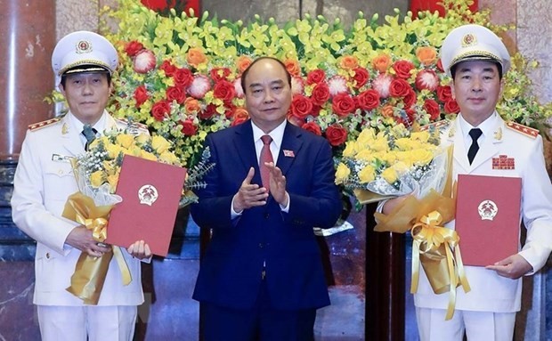 President Nguyen Xuan Phuc (middle) presents the promotion decisions to two deputy ministers of public security. (Photo: VNA)