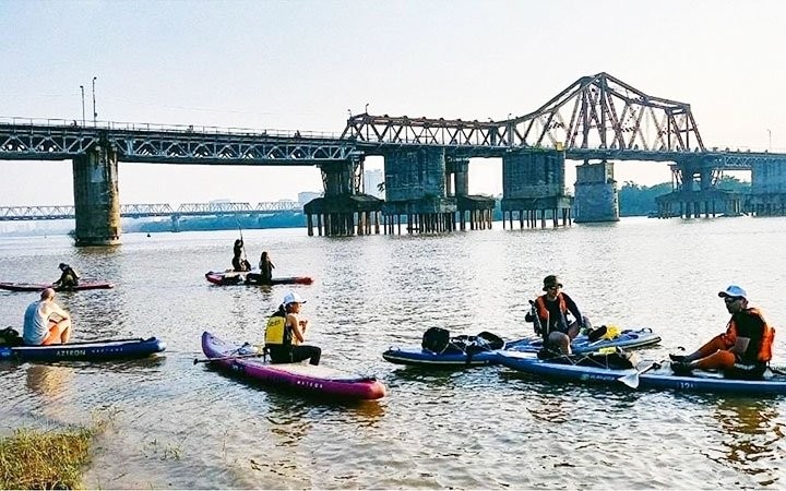 A group of tourists experiencing stand-up paddle boarding (SUP) on the Red River. (Photo: NDO/Hoang My Hanh)