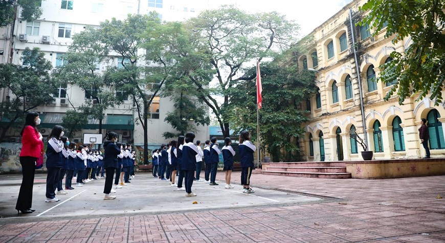Together with other students in Ha Noi, 12th graders of Viet Duc high school return to face-to-face learning on Feb. 7. On the first day coming back to school, they are eager to attend the flag salute ceremony. (Photo: VNA)