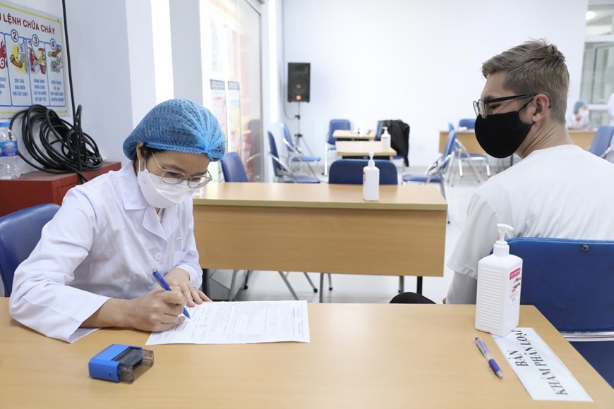 Health check before receiving COVID-19 vaccination in Hai Ba Trung District, Hanoi. (Photo: VNA)
