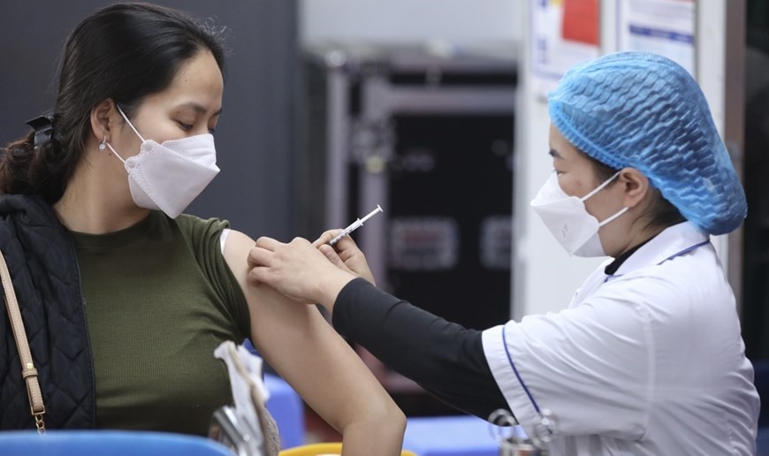 A woman receives an injection as Vietnam starts Spring COVID-19 vaccination campaign. (Photo: VNA)