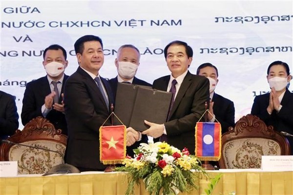 Vietnamese Minister of Industry and Trade Nguyen Hong Dien (left, front) and his Lao counterpart Khampheng Xaysompheng exchange an agreement on border cooperation in Vientiane on April 11. (Photo: VNA)
