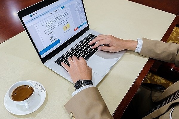 A businessman ratifies his electronic contract via his laptop. (Photo qltt.vn)