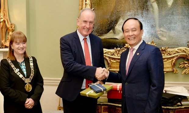 Vice Secretary of Hanoi Party Committee and Chairman of the People’s Council Nguyen Ngoc Tuan (R) presents gifts to Chief Executive of Ireland's Dublin City Owen P. Keegan. (Photo: VNA)