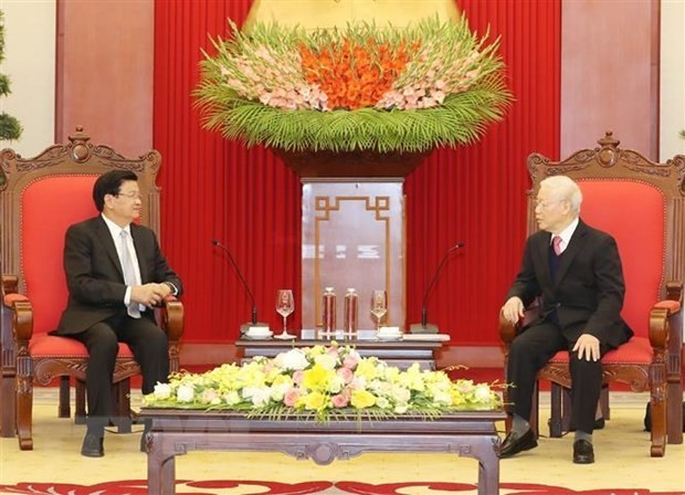 Party General Secretary and State President Nguyen Phu Trong (R) receives Lao Party General Secretary and Prime Minister Thongloun Sisoulith on December 2020 in Hanoi (Photo: VNA)