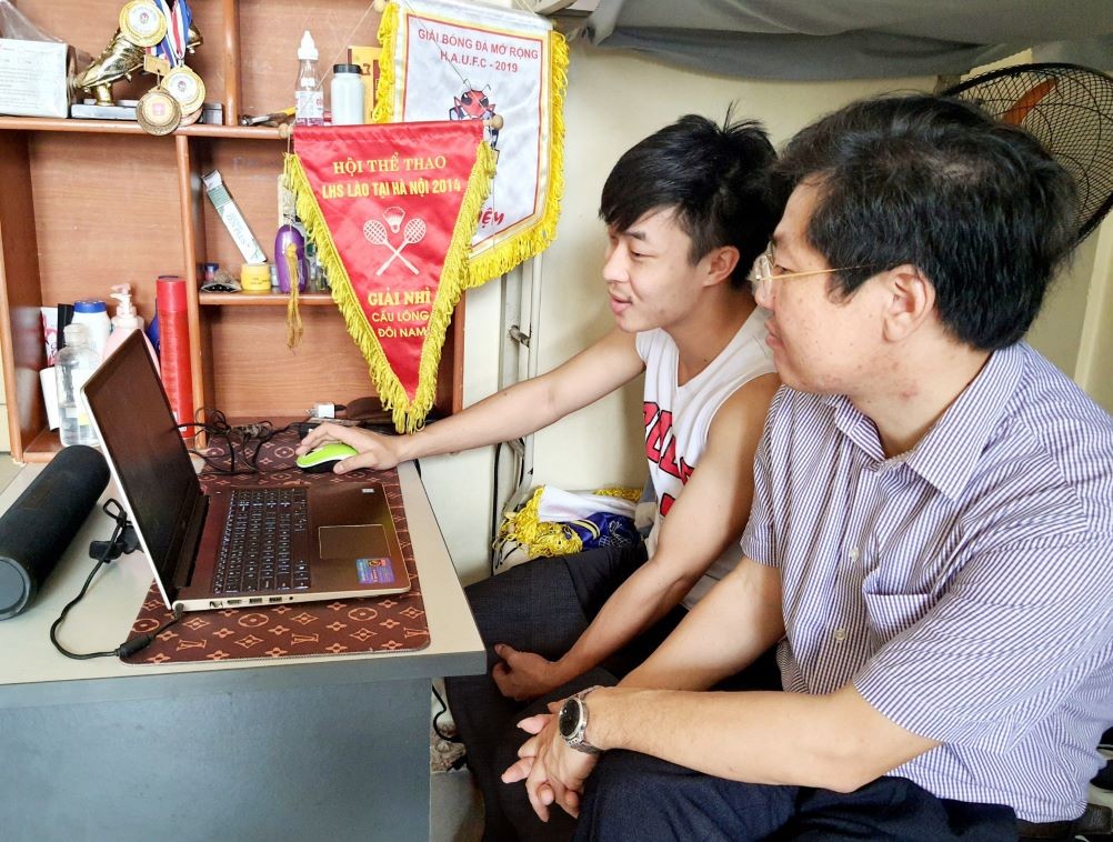 Thầy giáo, Ts. Phạm Đình Khuê đang hỏi han sinh viên người Lào, Phathana Keoinda tại phòng Ký túc xá. (Ảnh: Nguyễn Như Tuấn).
