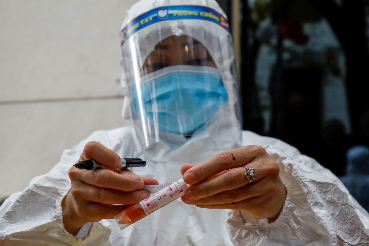 Một nhân viên y tế dán nhãn cho một ống mẫu xét nghiệm trong đợt bùng phát coronavirus ở Hà Nội, Việt Nam.  (Ảnh: Reuters)