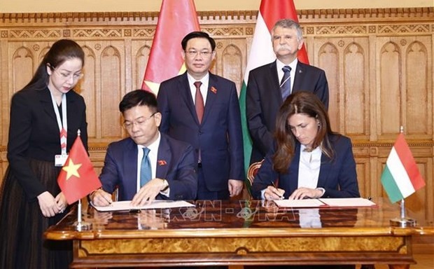 Vietnamese Minister of Justice Le Thanh Long (L) and his Hungarian counterpart Judit Varga sign the cooperation pact under the witness of National Assembly Chairman Vuong Dinh Hue and his Hungarian counterpart László Kovér. (Photo: VNA)