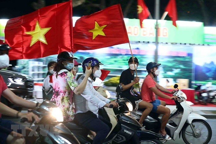 Người dân Thủ đô đeo khẩu trang phòng chống dịch Covid-19 khi tham gia giao thông mừng chiến thắng của U23 Việt Nam. (Nguồn: TTXVN)