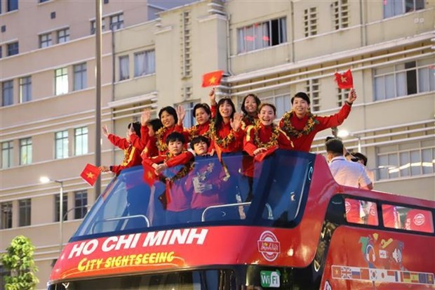 Female players wave at local fans from a double-decker bus along HCM City streets on February 11. (Source: VNA)