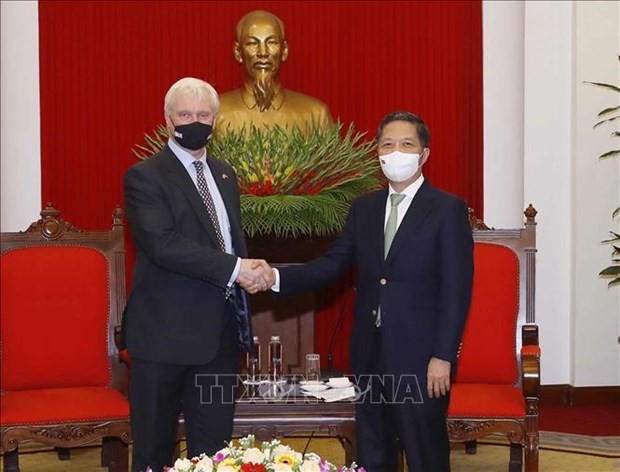 Politburo member and head of the Party Central Committee's Economic Commission Tran Tuan Anh (R) shakes hands with Graham Stuart, UK Prime Minister's Trade Envoy to Vietnam, Cambodia and Laos 