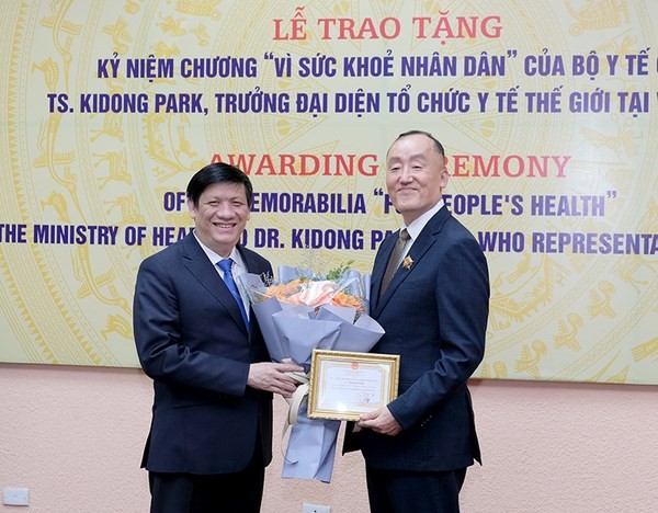 Minister of Health Nguyen Thanh Long awarded Dr Kidong Park the  insignia 'For the Health of the People'. (Photo: VNA)