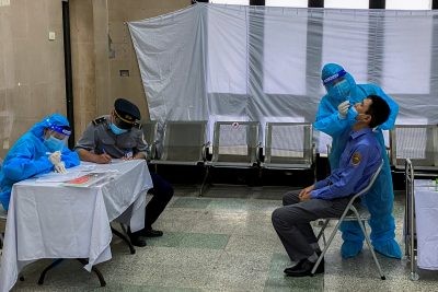 A healthcare worker takes a nasal swab sample from a worker for a coronavirus disease (COVID-19) test, at Hanoi train station in Hanoi, Viet Nam, 13 October 2021 (Photo: Reuters)