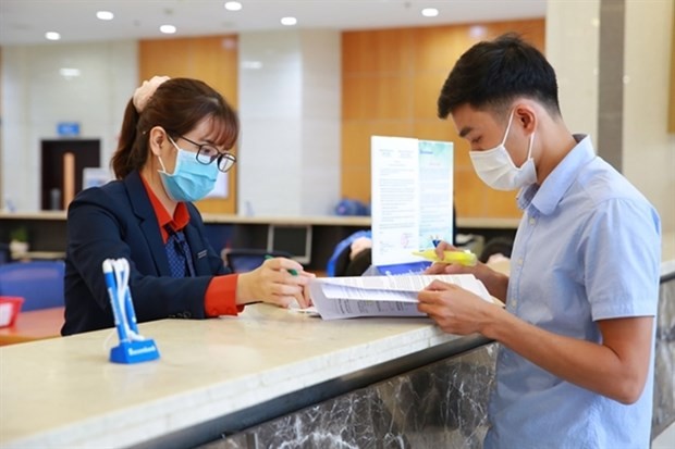 A client conducts a bank transaction at Sacombank. (Photo: dangcongsan.vn)