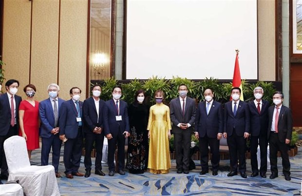 Participants in the meeting between President Nguyen Xuan Phuc (fourth from right) and Grab President Ming Maa (fifth from right) in Singapore on February 25 (Photo: VNA)