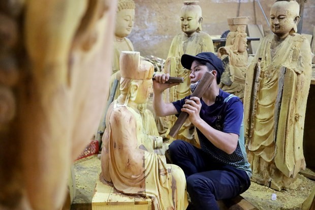 A worker carves a statue in Son Dong village of Hanoi's Hoai Duc district. Son Dong village is known for making worship objects. (Photo: VNA)