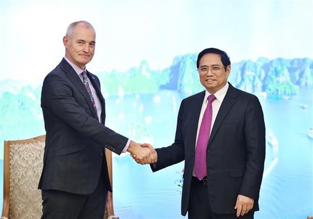 Prime Minister Pham Minh Chinh (R) shakes hands with President of the RMIT University Prof Alec Cameron (Photo: VNA)