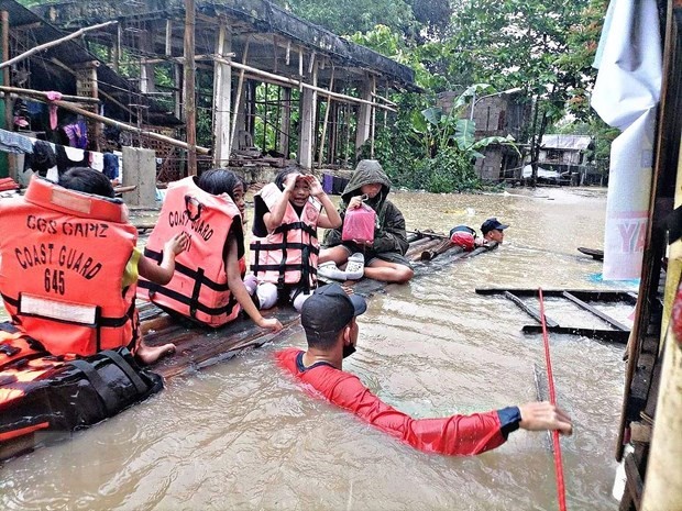 Rescuers evacuate residents from a flooded area in Storm Megi in Panitan town of Capiz province, the Philippines, on April 12. (Photo: AFP/VNA)