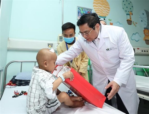 Prime Minister Pham Minh Chinh presents a gift to a child patient at the National Children's Hospital on May 31. (Photo: VNA) 