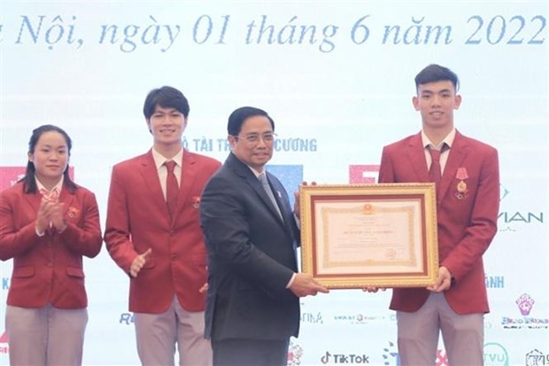 Prime Minister Pham Minh Chinh (front, left) presents a second-class Labour Order to swimmer Nguyen Huy Hoang. (Photo: VNA)