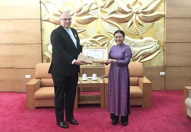 Danish Ambassador to Vietnam Kim Højlund Christensen (L) receives the insignia “For peace and friendship among nations”. (Photo:VNA)