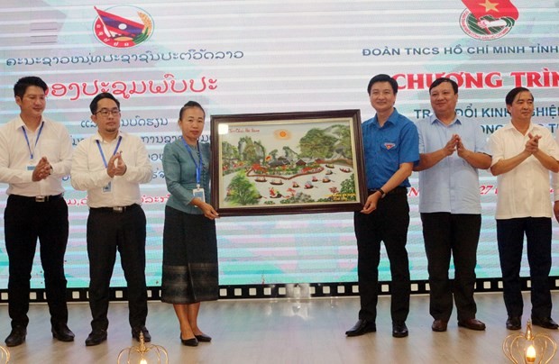 Secretary of the Ha Nam HCYU Committee Tran Ngoc Nam (third from right) presents a gift to the LPRYU delegation on July 27. (Photo: VNA)