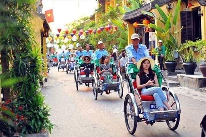 Tourists go around Hoi An ancient town by cyclo. (Photo: VNA)