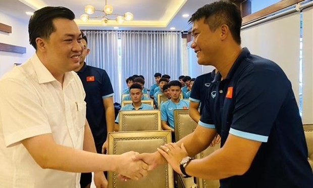 Deputy Director of the Binh Duong Department of Culture, Sports and Tourism and VFF Vice President Cao Van Chong (left) meets the Vietnamese footballers to wish them luck and success before their departure to Indonesia. (Photo: VNA)