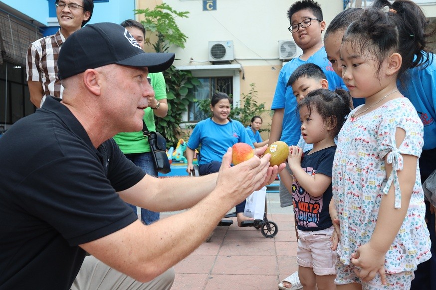 Tổng Lãnh sự Joe Nelson tặng táo và kiwi New Zealand cho trẻ em tại Làng May mắn. (Nguồn: ĐSQ NZ tại Việt Nam)