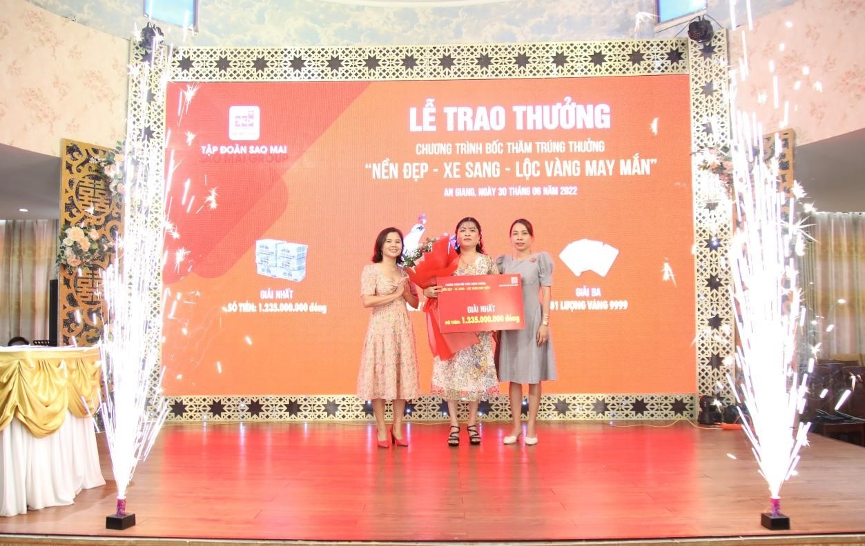 Le Thi Phuong, deputy general director of Sao Mai Group, and a representative of the An Giang Department of Industry and Trade present the first prize to Nguyen Thi Hop